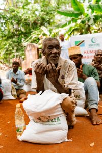 Notre Action A community gathering for food distribution in an outdoor setting.